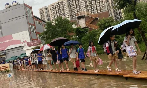 Hà Nội ngập sâu, trường học kê bàn thành 'cầu' cho học sinh ra về