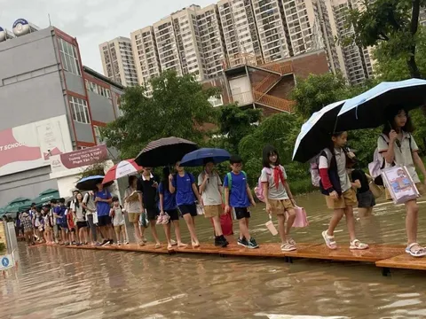Hà Nội ngập sâu, trường học kê bàn thành 'cầu' cho học sinh ra về